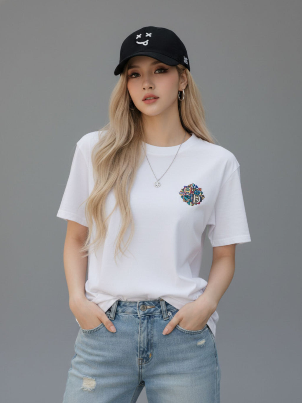 Woman wearing MOOD signature black cap XX with white t-shirt with a colorful design and blue jeans against a gray background