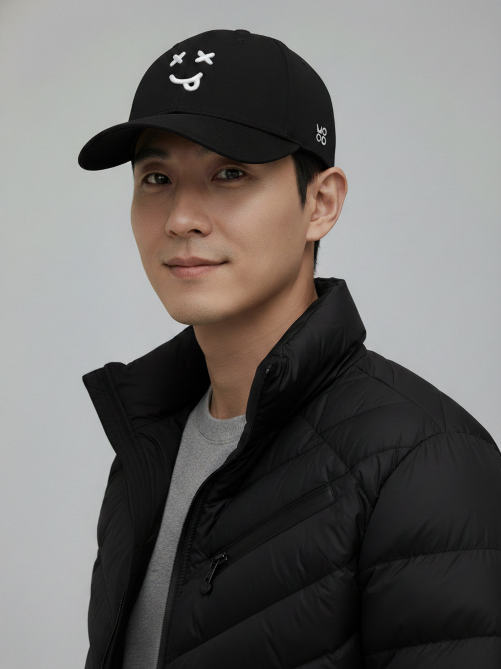 Person wearing MOOD signature black cap XX and black jacket on a gray background
