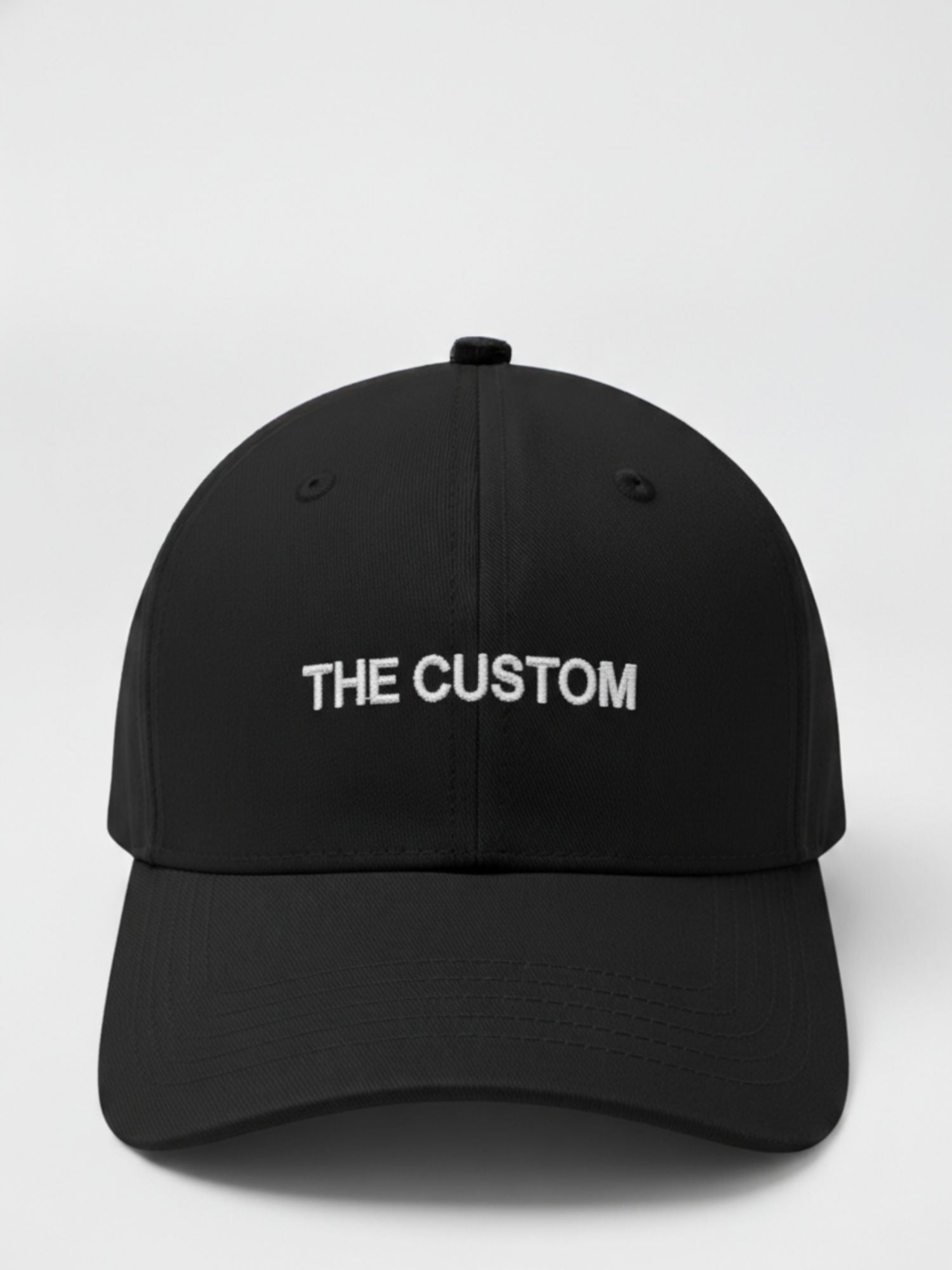 Black cap with 'THE CUSTOM' text on a white background