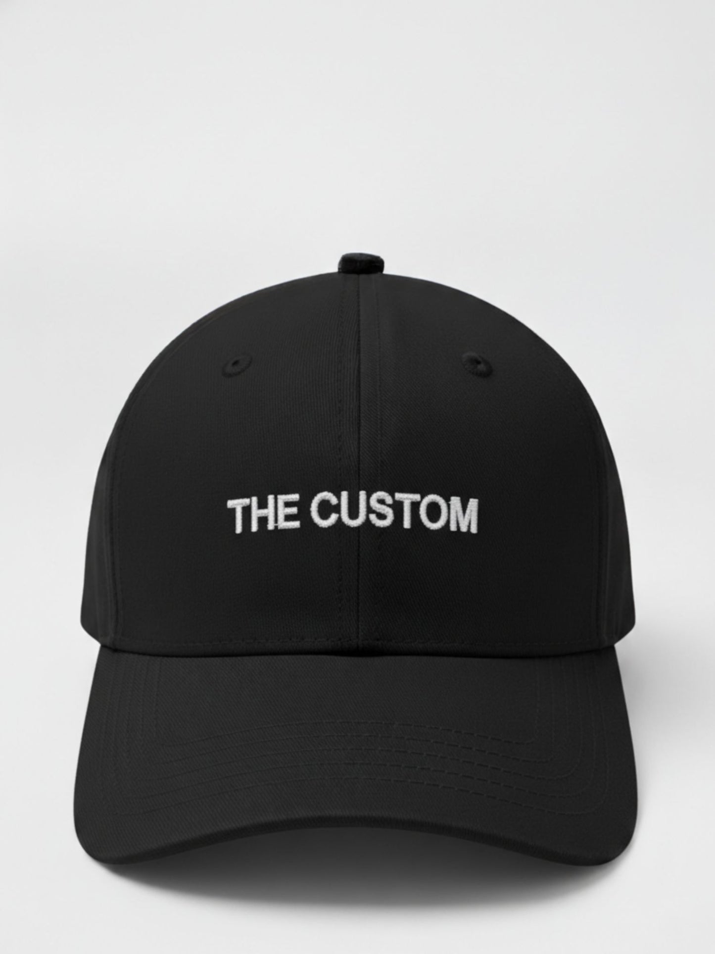 Black cap with 'THE CUSTOM' text on a white background