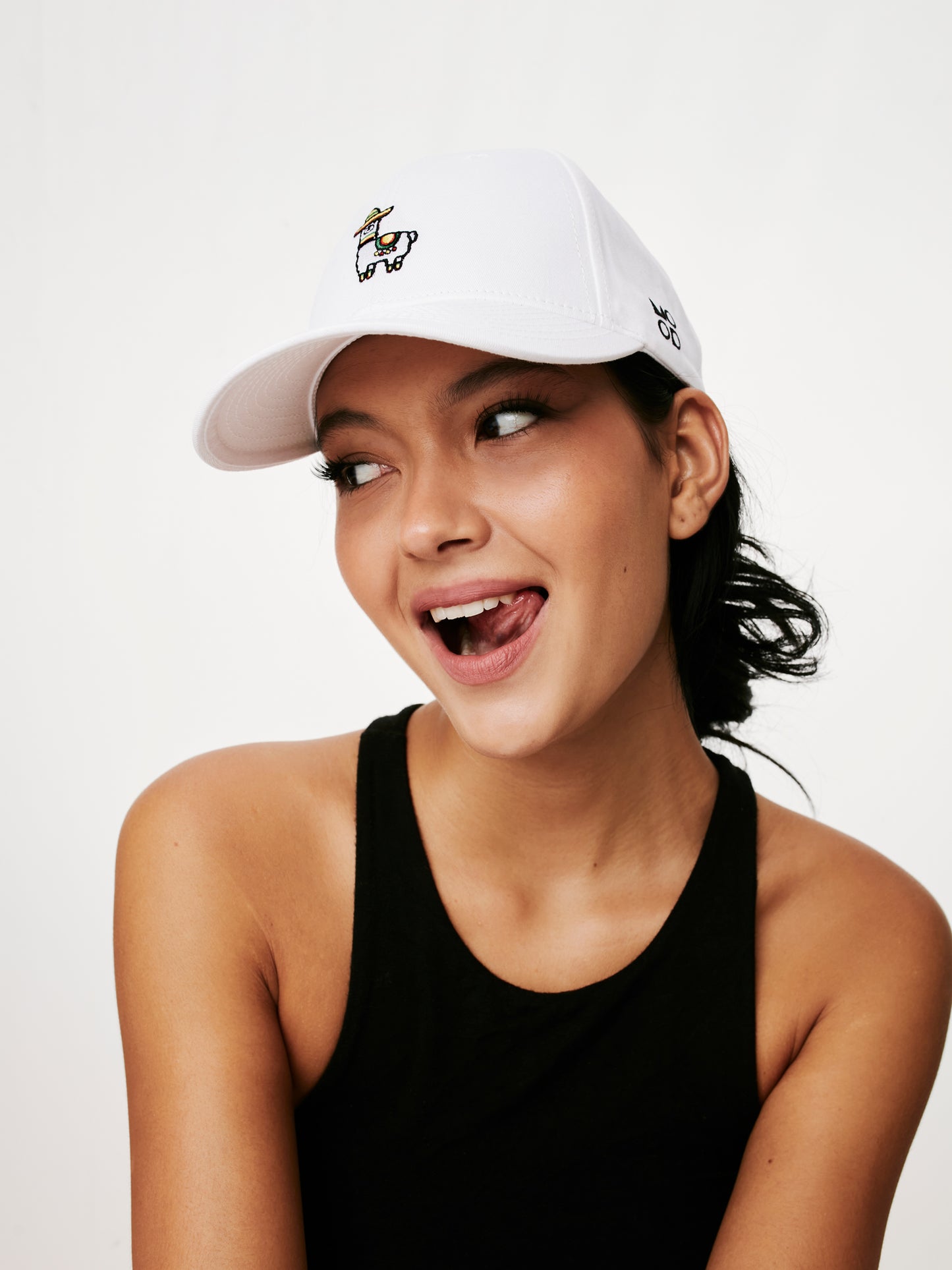 MOOD female model wearing Mexillama baseball cap in white color product shoot, looking cheeky