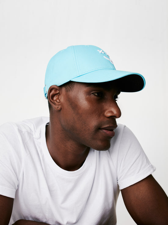 MOOD male model wearing XX baseball cap in paradise blue, looking to his left