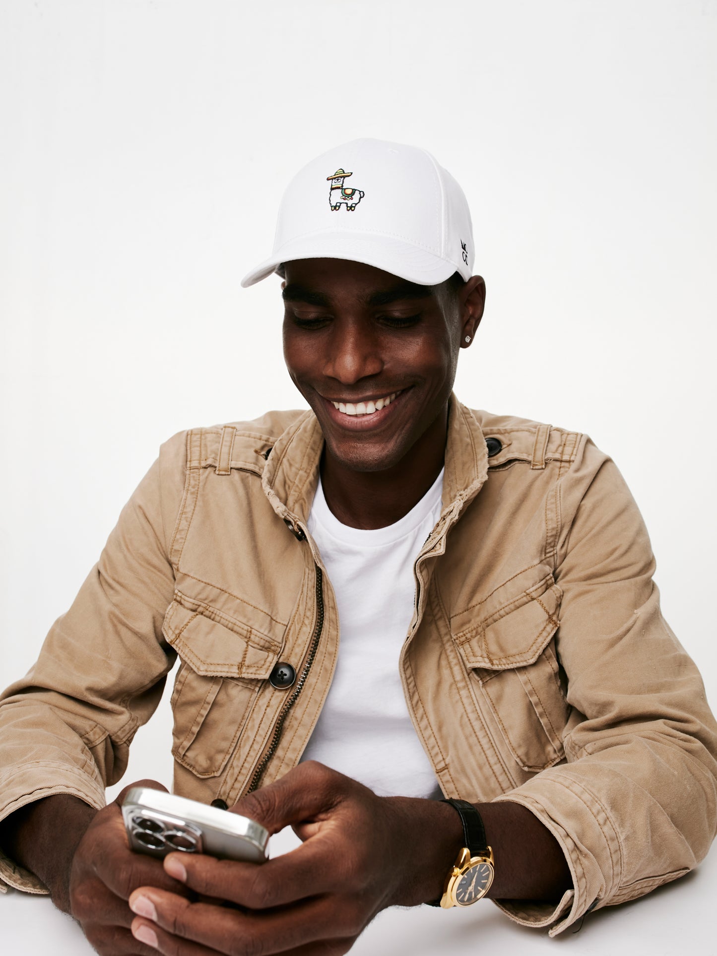 MOOD male model wearing Mexillama baseball cap in white color product shoot and smiling using his phone